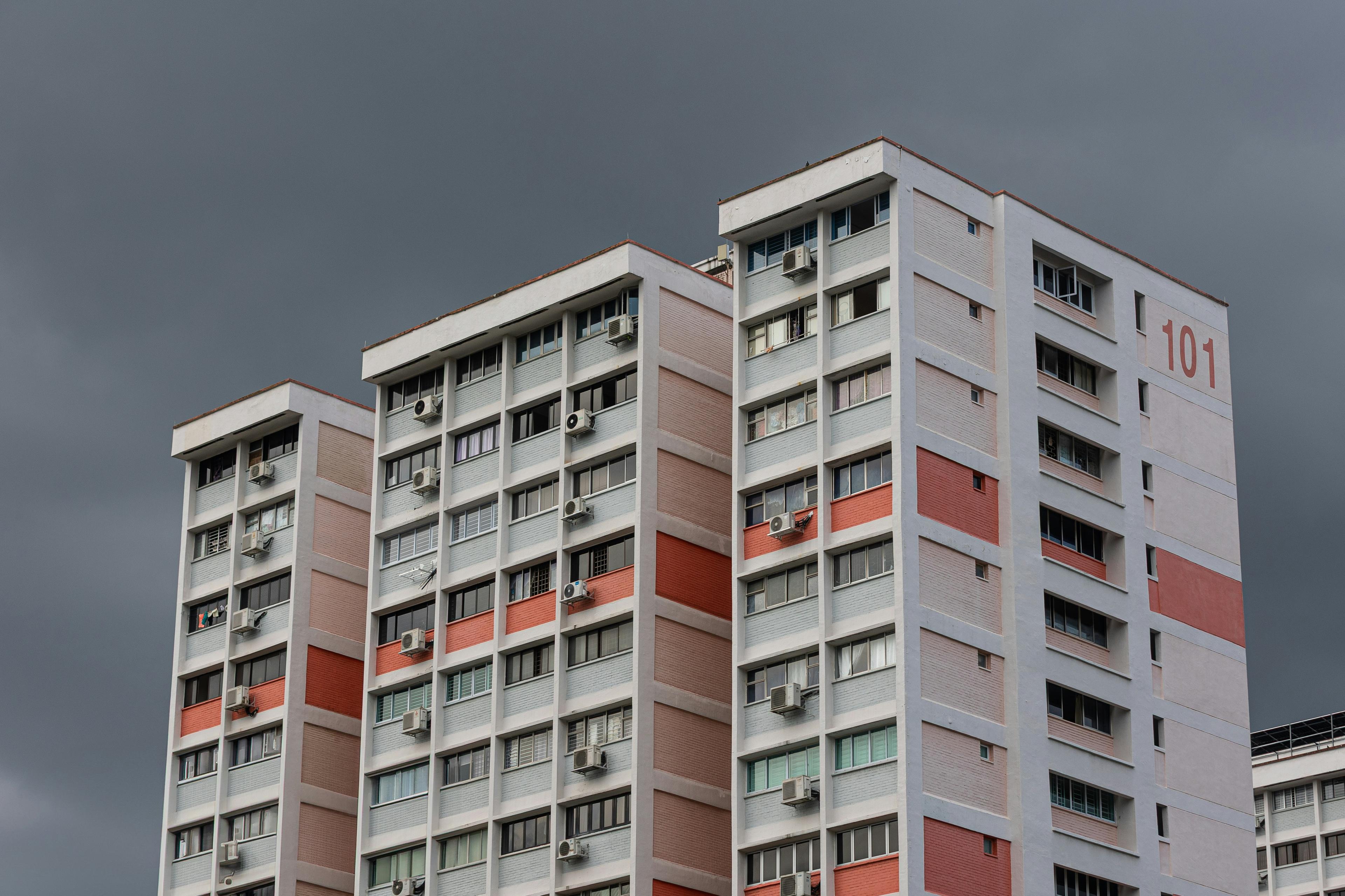HDB blocks with red panels beneath a stormy sky